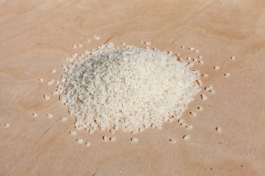 Çiğ, yuvarlak pirinç. Yığınla pirinç. Ahşap bir arka planda pirinç güveci yapmak için kullanılır. Çiğ ürün. Hasat günü. Yiyecek malzemesi.