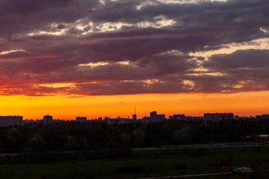 Şehrin üzerinde gün batımı. Güzel bulutlu gün batımı gökyüzü