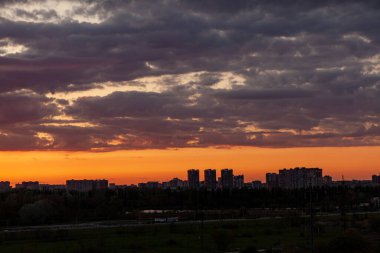 Şehrin üzerinde gün batımı. Güzel bulutlu gün batımı gökyüzü