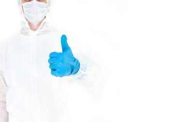 Koruyucu takım elbiseli, eldivenli ve maskeli bir adam. Benzer bir jest. Beyaz bir arkaplanda izole edilmiş