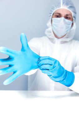 Koruyucu takım elbiseli ve maske takan eldiven takan bir adam. Sağlık hizmeti kavramı.