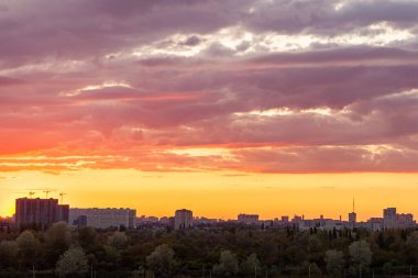 Şehrin üzerinde gün batımı. Güzel bulutlu gün batımı gökyüzü