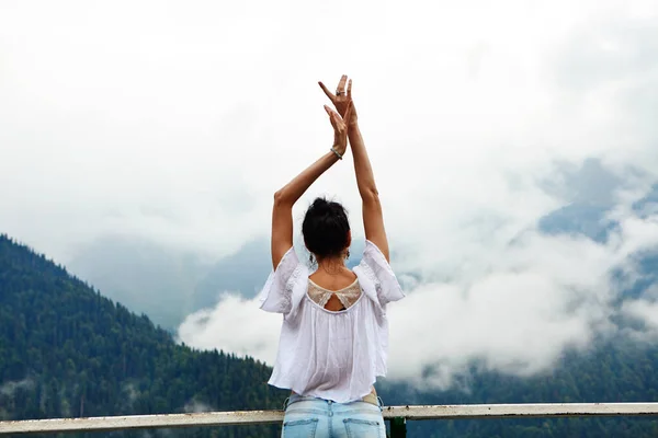 stock image A girl in white clothing on a background of a mountain lake with blue water and mountains with clouds. Background.