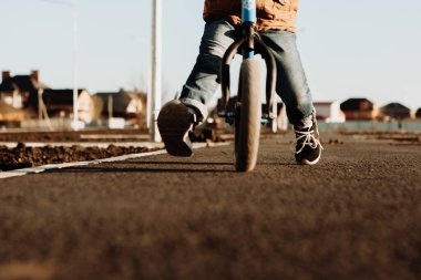 Bir çocuk dengeleyici bisiklet sürüyor. Etkin yürüyüş