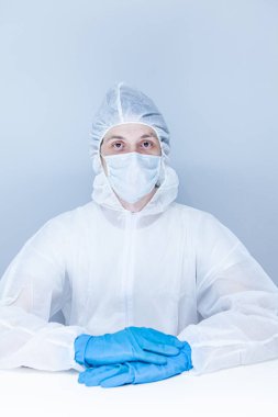 Koruyucu giysili, eldivenli ve maskeli bir adam. Sağlık hizmeti kavramı.