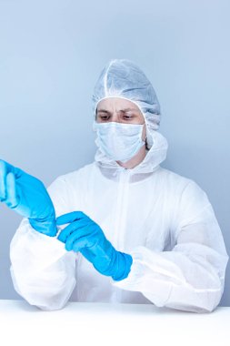 Koruyucu giysili, eldivenli ve maskeli bir adam. Sağlık hizmeti kavramı.