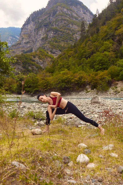 自然の中でヨガのクラス 女性は山の中でヨガをします 山の川の近くに流れます 一人でスポーツをするというコンセプト 社会的排除 — ストック写真