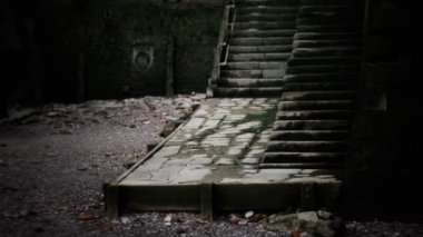 Eski duvar ve merdivenler yosunla kaplı.