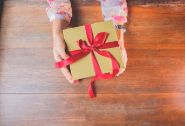 Kırmızı kurdele ya da hediye paketi kadınların elinde. Noel ya da doğum günü hediyesi ve şükran günü, daha fazla kavram verir. Sevgililer Günü 'nde sevgi gösteren insanlar.