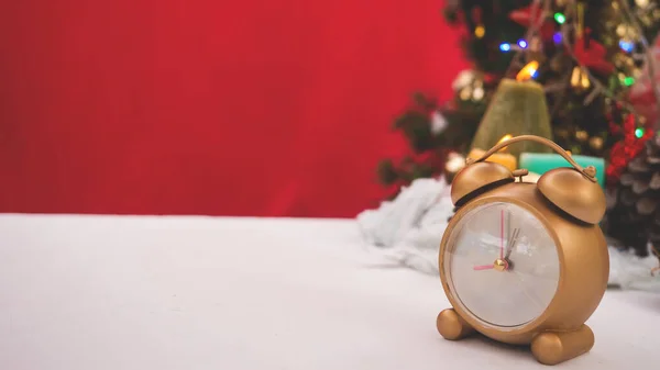 Noel kutlaması temalı altın saat beyaz masa başı arka planında fotokopi alanı ile süslenmiş aile kışın Noel tatilinde birlikte vakit geçirmiş. 
