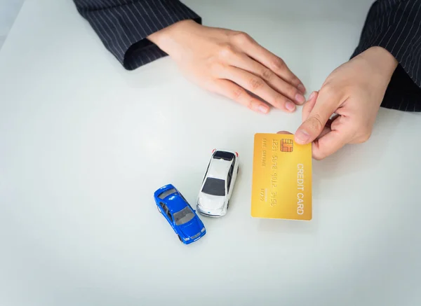 Topview, iş kadını elinde yeni araba almak ya da arabaya yatırım yapmak için kredi kartı tutuyor. Beyaz arkaplanda kopyalama alanı