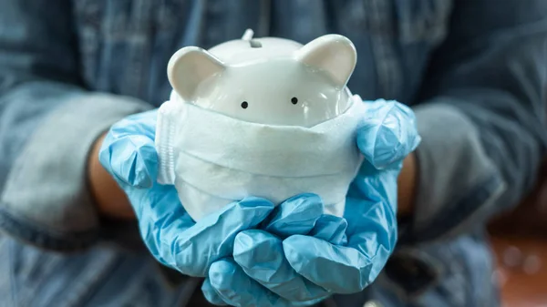 Hand Trägt Handschuhe Mit Sparschwein Medizinischer Gesichtsmaske Geld Sparen Für Stockfoto