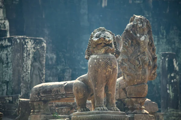 Old stone statue of sacred beast lion. Khmer lion guardians statue of Angkor Wat temple complex in Siem Reap of Cambodia.