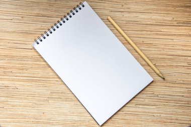 Ahşap arka planda kalem olan defter. Rahat bir çalışma alanı. Üst manzara, düz uzanma.