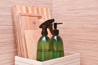 Mutfakta bulaşık deterjanı var. Kesme tahtaları ve plastik şişelerde dezenfektan sıvısı olan kutu..