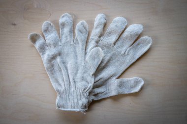 Ahşap arka planda temiz beyaz iş eldivenleri.