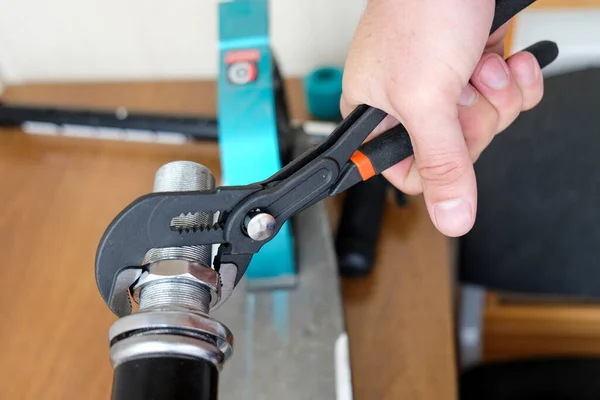 unscrew the nut with an adjustable wrench. repair of household items at home.