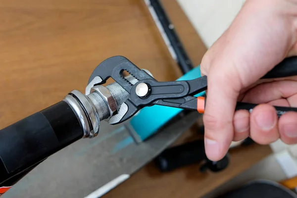 unscrew the nut with an adjustable wrench. repair of household items at home.