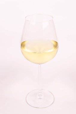 Beyaz arka planda bir bardak beyaz şarap..