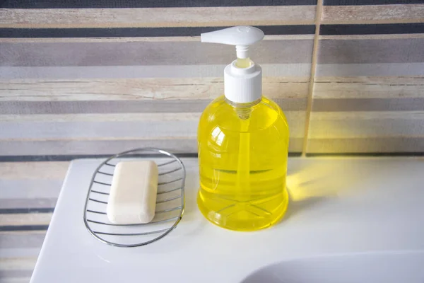 浴室水池上的肥皂旁边是黄色的液体肥皂 — 图库照片