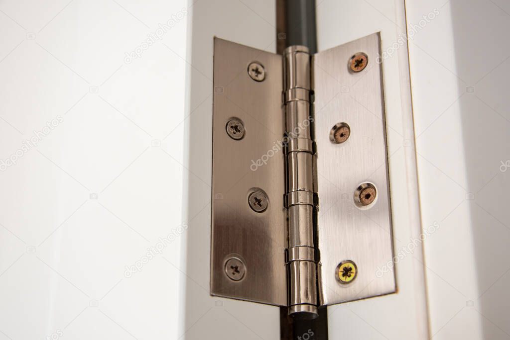 door hinges Aluminum on white door close up.