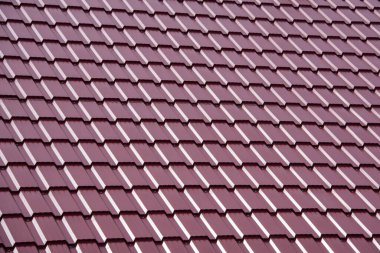 Modern kırmızı metal çatı kiremitleri olan kırsal bir evin çatısı..