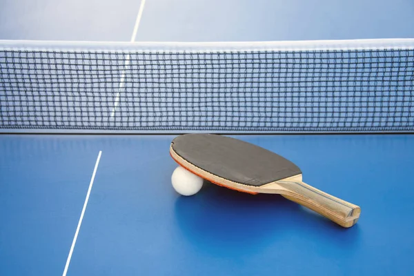 Fekete Ütő Ping Pong Fehér Labda Feküdt Kék Asztal Mellett — Stock Fotó