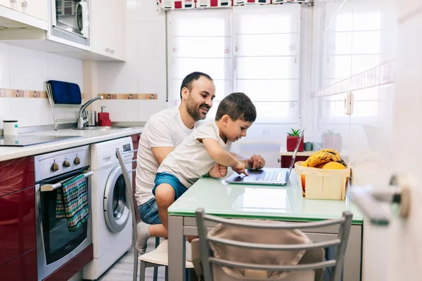 Un padre y su hijo en casa con la computadora —  Fotos de Stock