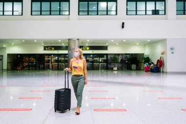 Havaalanında bavullu bir kadın var.