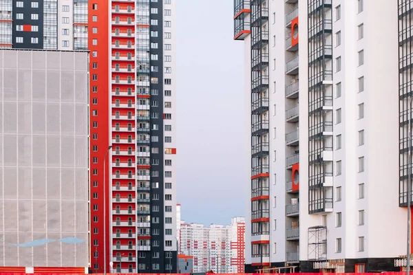 Kırmızı beyaz ve gri çizgili yüksek katlı bir binanın cephe. Mavi gökyüzüne karşı çok katlı bina. Göstermek için arka plan.