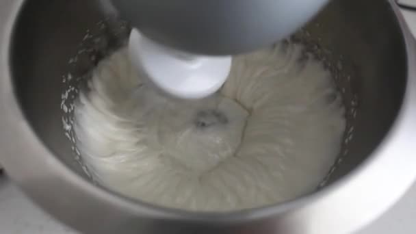 믹서가 달걀 흰자와 설탕을 강철 그릇에 넣습니다.. — 비디오