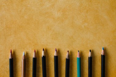 Sarı renk kopyalama alanının dokusal kağıt arka planına tıkanmış kalemler