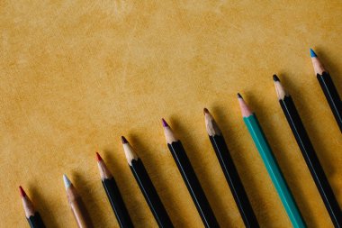 Sarı renkli kopya alanı bir dokusal Kağıt arka plan üzerinde renkli kalemler