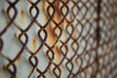 Paslı bir çelik duvarın arkasında paslı bir rabitz. Yan görünüm.