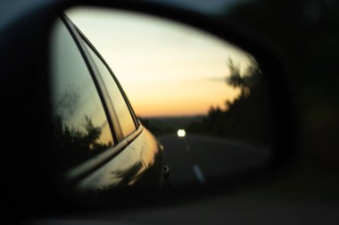 Bir yaz sabahında bir arabanın yan aynasında yolu göstermek..