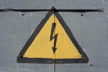 Transformatörün metal kapısında yüksek voltajlı uyarı işareti var..