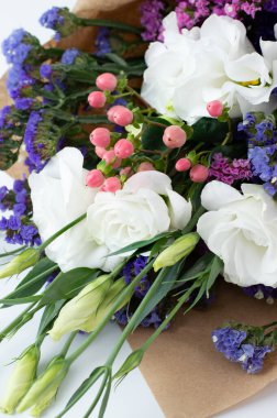 Beyaz Eustoma, pembe hiperikum, renkli limonyum içeren narin bir buket..