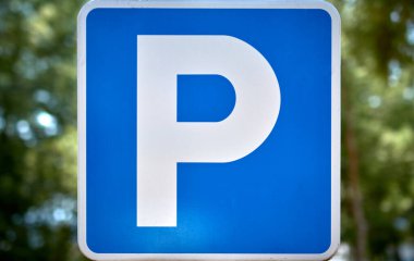 Ağaçlı bir caddede park işaretinin ayrıntıları