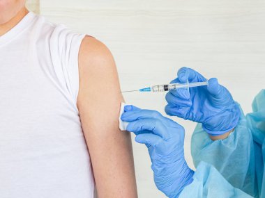 Bir hemşire, insanı koronavirüs enfeksiyonuna karşı aşı yapar. Coveid-19 salgın hastalık konsepti.