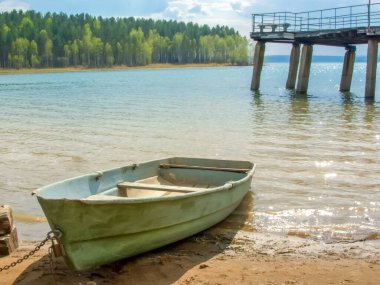 Güneşli bir yaz gününde sahilde eski ahşap bir tekne.,