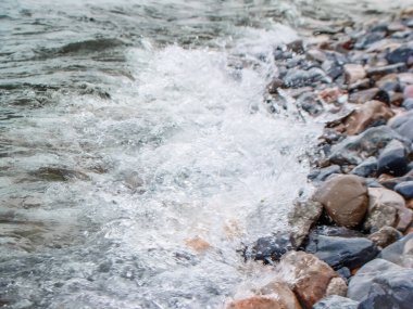Şiddetli bir dağ nehrindeki suyun arka planı. Taş ve suyun güzel doğal arka planı. Temiz suyun dokusu ve hızlı bir nehir...