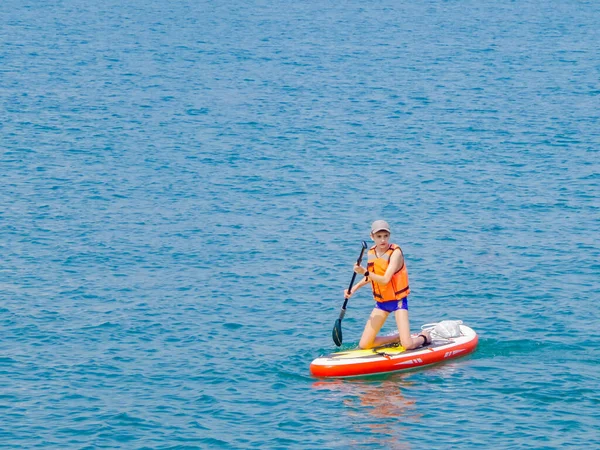 滑浪冲浪板上的一位年轻骑手用桨拍打海浪 这是一种积极生活方式的概念 — 图库照片