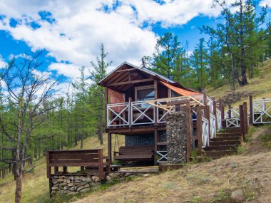 Dağlarda bir ormandaki eski ahşap bir evin manzarası.