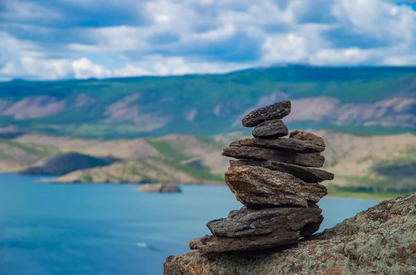 禅の概念 バイカル湖を背景に山の上に石で作られたピラミッド 瞑想のための石ピラミッド 調和と瞑想 — ストック写真