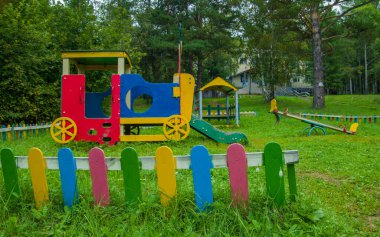 Parktaki oyun parkı ağaçların arasında.