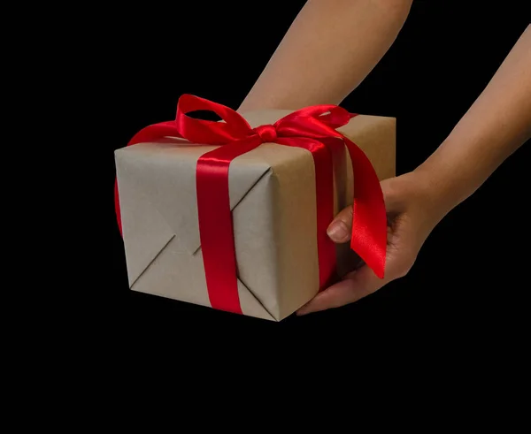 hands hold gift box with red ribbon, copy space isolated on black. Sales concepts, discount price, christmas gifts and shopping, greeting card for christmas, valentine\'s day or new year..