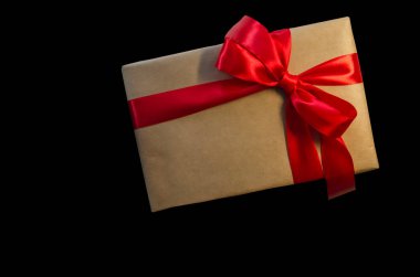 Kırmızı kurdeleli hediye kutusu, siyah arkaplanda izole edilmiş kopyalama alanı. Satış konseptleri, indirimli fiyatlar, Kara Cuma, Noel hediyeleri ve alışveriş, Noel için tebrik kartı, sevgililer günü veya yeni yıl