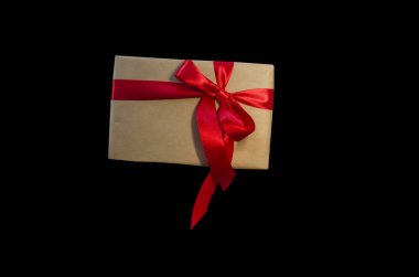 Kırmızı kurdeleli hediye kutusu, siyah arkaplanda izole edilmiş kopyalama alanı. Satış konseptleri, indirimli fiyatlar, Kara Cuma, Noel hediyeleri ve alışveriş, Noel için tebrik kartı, sevgililer günü veya yeni yıl