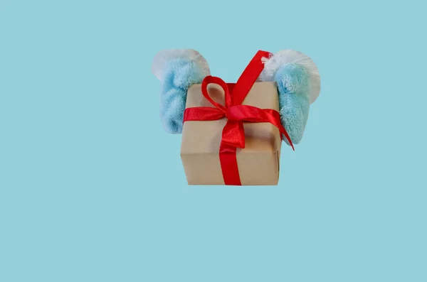 圣诞老人送给我们一个带有红丝带的礼品盒 复制一个用浅蓝色背景隔开的空间 圣诞礼品及购物的概念 圣诞或新年贺卡 — 图库照片