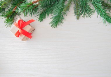 Hafif bir arka planda noel toplarıyla süslenmiş ladin dalı, noel kartı